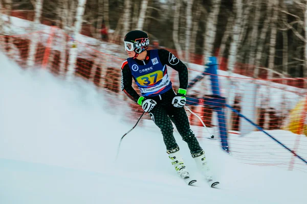 Man athlete after finish spray of snow during Russian Cup in alpine skiing