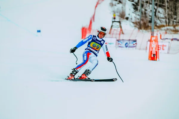 Young athlete male skier after finish of race downhill from mountains during Russian Cup in alpine skiing
