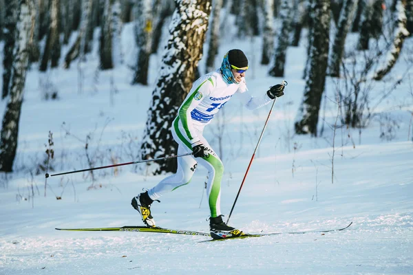 Male athlete skier during race in forest classic style hill climb