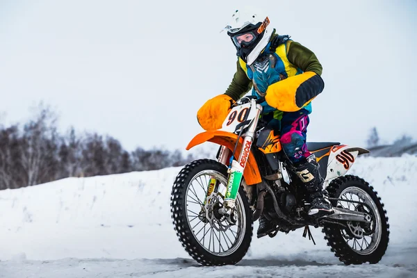 Closeup man motorcycle racer on a snow-covered race track