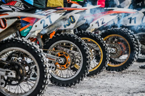 Closeup of wheels of motorbikes standing at starting line