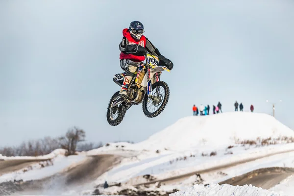 High jump motorcycle racer on snow covered hill