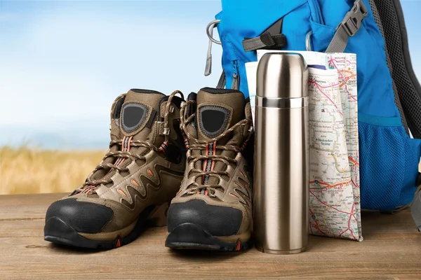 Hiking boots, backpack and map