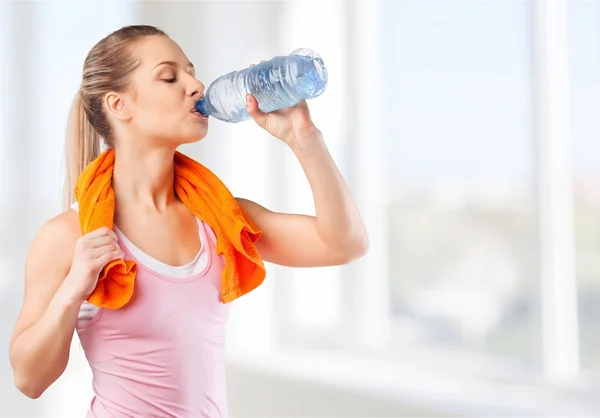 woman drinking water after work out