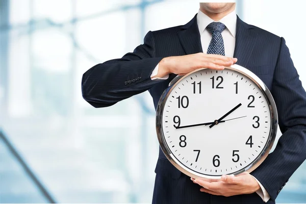 Businessman holding clock in hands