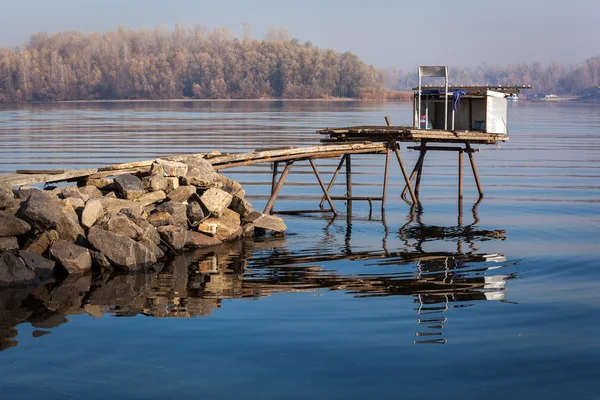 Makeshift bridge for fishing, stone embankments, river, fishing