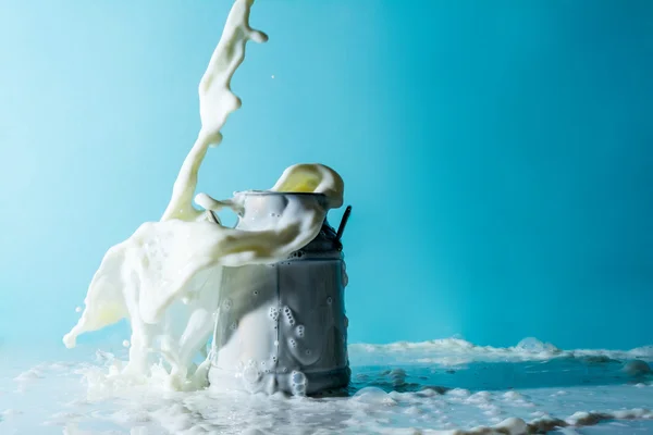 Splashes of milk, stream jet of milk pours pouring into a can of milk