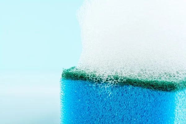 Sponge with  foam and reflection, bubbles, close-up, texture, light blue background