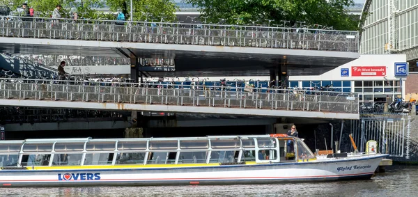 AMSTERDAM, NETHERLANDS - MAY 28, 2015: Tour-boat and parking of bicycles.