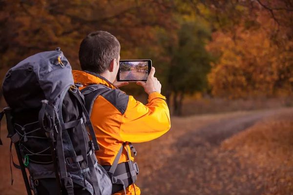 Male tourist with digital tablet, autumn