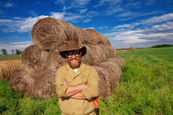 Portrait of smiling farmer in hay field