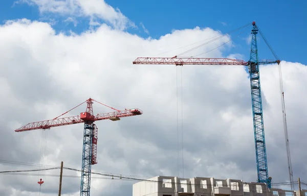 Hoisting cranes on the construction of building.