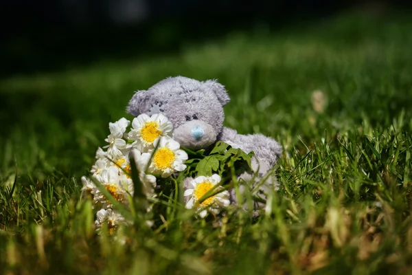 Soft plush teddy bear with flower