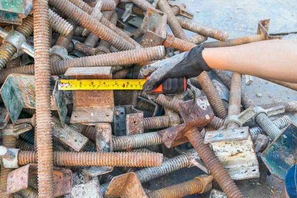 Hand Tools Measuring tape with steel bolts, nuts, screws scaffolding pole.