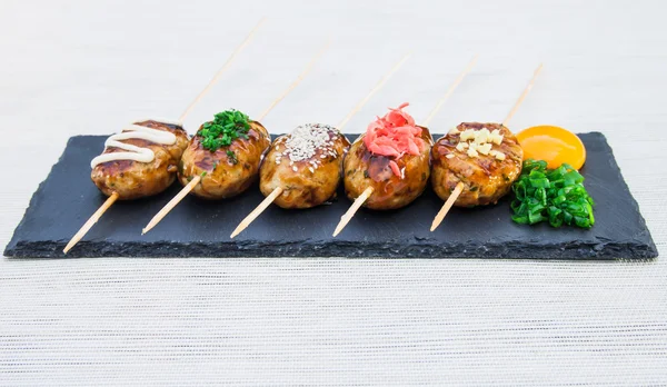 Japanese skewers of chicken with soy sauce and sesame seeds