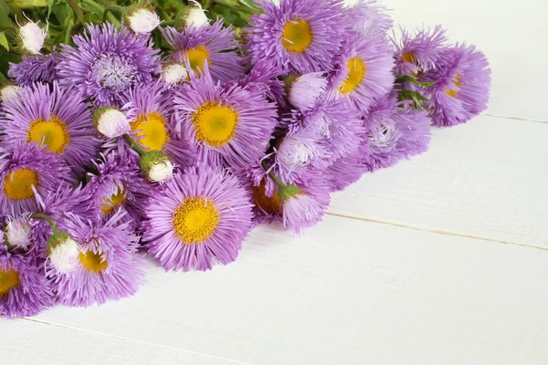 Bouquet of light purple flowers on white painted wooden table. Closeup
