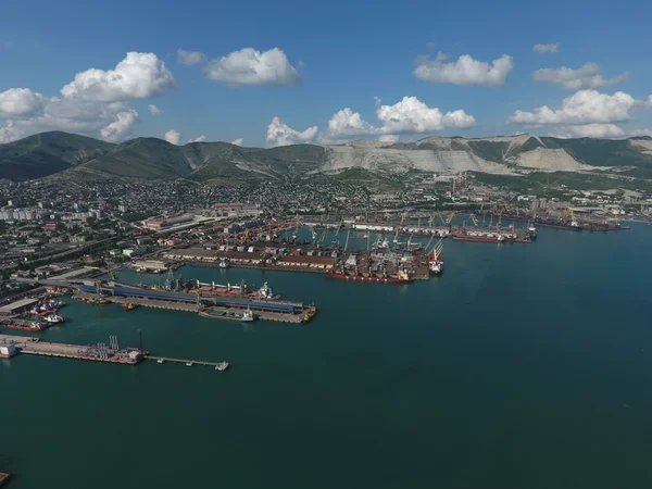 Industrial seaport, top view. Port cranes and cargo ships and barges.