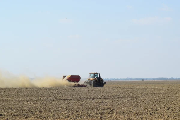 Tractor rides on the field and makes the fertilizer into the soil. Fertilizers after plowing the field.