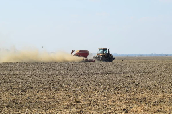 Tractor rides on the field and makes the fertilizer into the soil. Fertilizers after plowing the field.