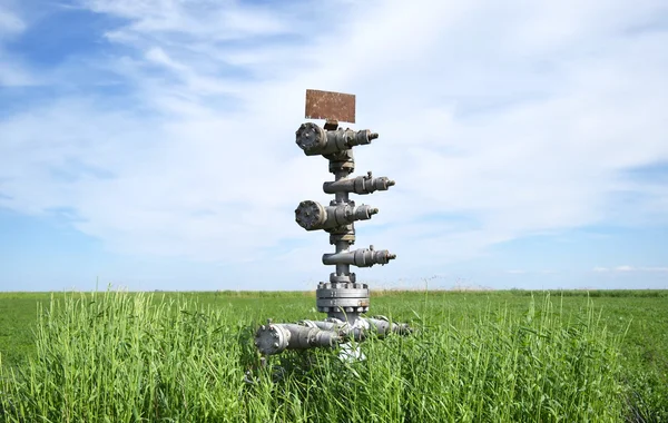 Canned oil well against the sky and field