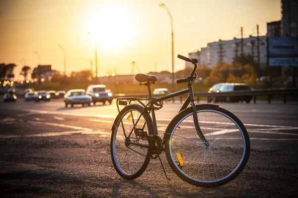Classic city bike on the road at sunset