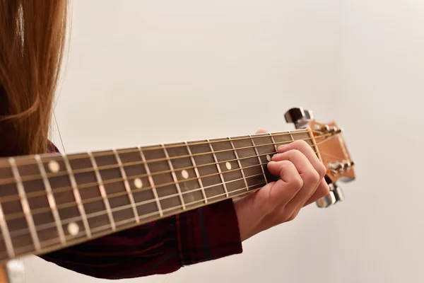 Woman's hands playing acoustic guitar, close up. Playing acoustic guitar girl or woman with long hair by fingers. finger position on the chord. selective focus image