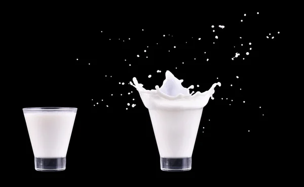 White fresh milk splash in glass on black background