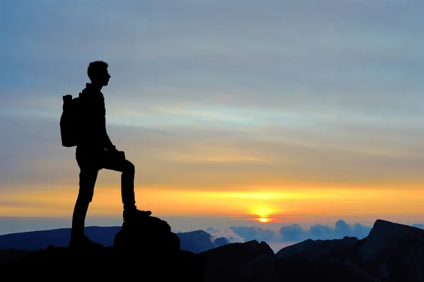 Silhouette of man at the top of the mountain on sunset. Beautiful landscape.