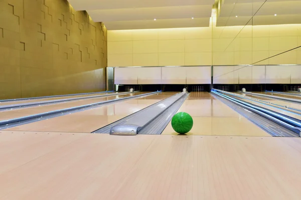 Bowling ball lying on bowling alley It will be strike. Green bowling ball rolling along bowling alley