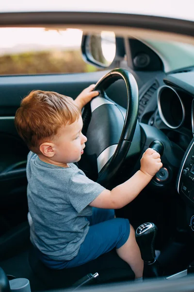 Cute little boy driving fathers car