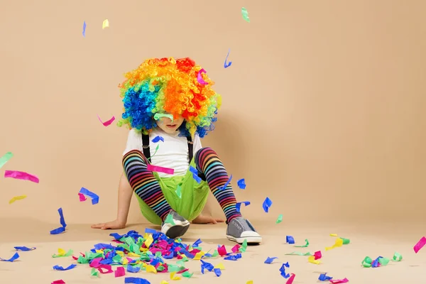 Happy clown boy with large colorful wig