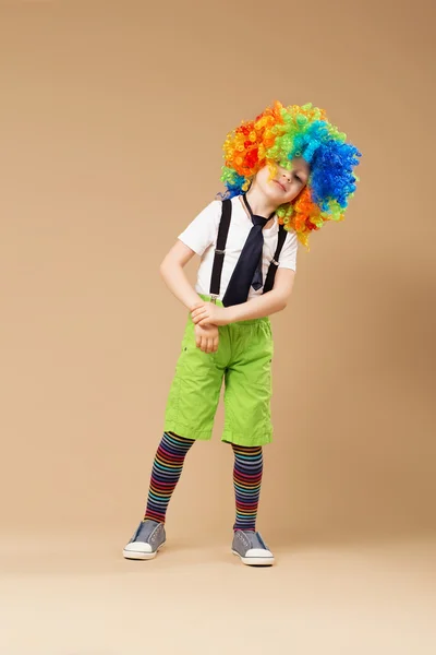 Little boy in clown wig dancing and having fun