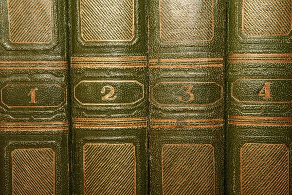Volumes of old books with gold lettering on the cover