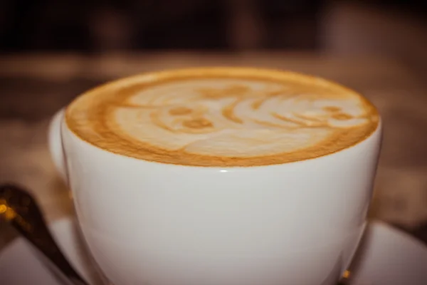 A cap of a funny decorated cappuccino