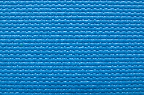 Blue fitness yoga mat surface texture close up.