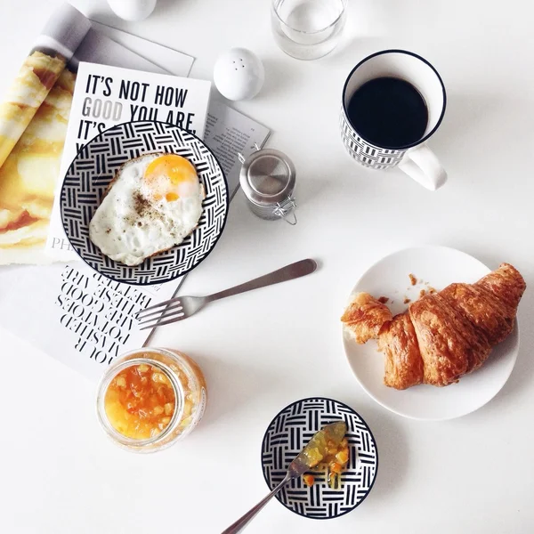 Breakfast with fried egg, croissant and coffee