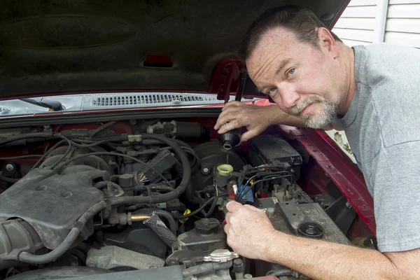 A Mechanis Pouring Brake Fluid Into A Master Cylinder On A Older