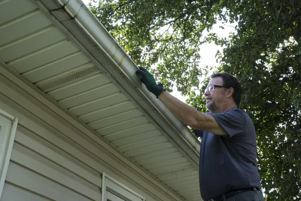 Cleaning Gutters Of Leaves And Sticks