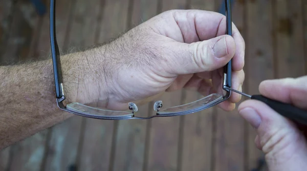 Using A Precision Screwdriver To Tighten Screw On Glasses