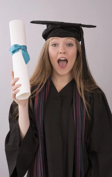 Graduate in cap and gown holding diploma