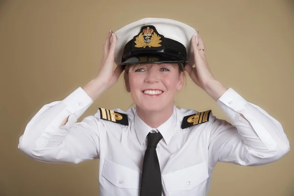 Female naval officer placing her hat onto her head