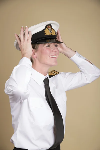 Female naval officer placing her hat onto her head