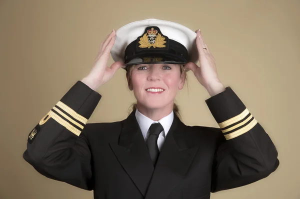 Female naval officer placing her hat onto her head