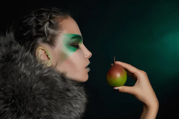 Fantasy woman in fur eating pear