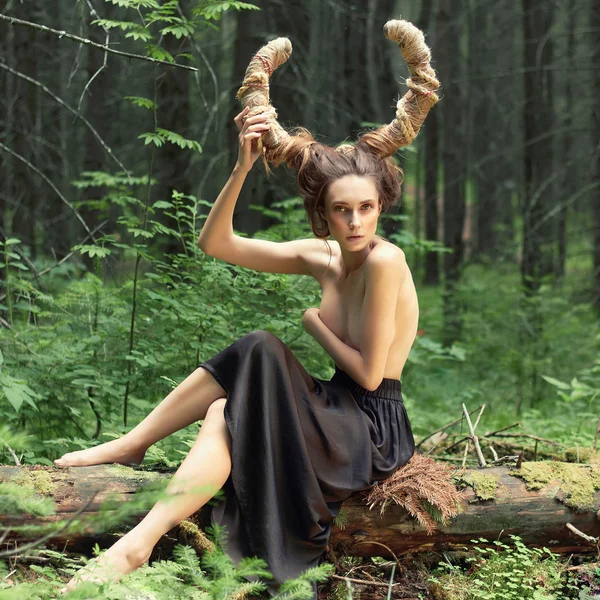 Fantasy girl with horns in woods