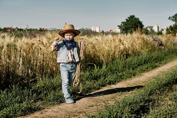 Little boy dressed in Western style in the field , retro style