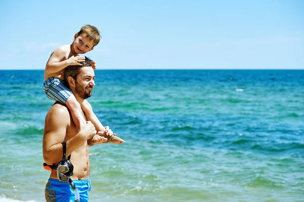 Father and son on the beach with underwater equipment . Father teaches son how to swim