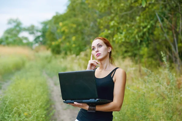 A young emotional girl with laptop in the Park