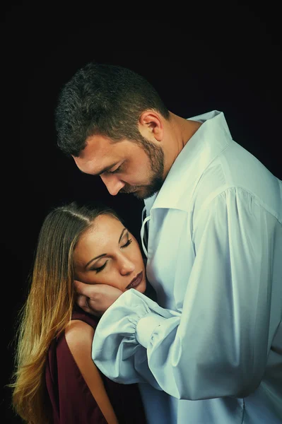 Portrait of beautiful romantic couple on a dark background