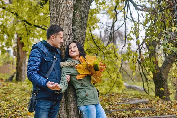 Love, relationship, family and people concept - smiling couple hugging in autumn park